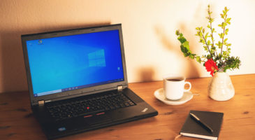 Laptop und Arbeitsmaterialien auf einem Schreibtisch im Homeoffice.